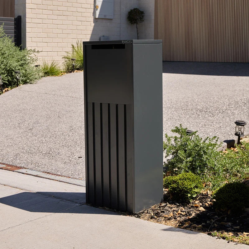 Empire Parcel Letterbox in grey steel installed at a home entrance beside the driveway and garage
