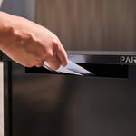 Empire Parcel Letterbox in grey steel with a hand posting an envelope through the mail slot