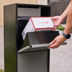 Zephyr Parcel Letterbox in charcoal steel with its front flap lifted while a parcel is loaded inside