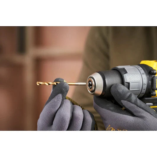 Person changing drill bit with gloves on against a blurred background