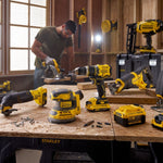 Workshop setting with a person using power tools on a workbench, surrounded by various Stanley power tools.