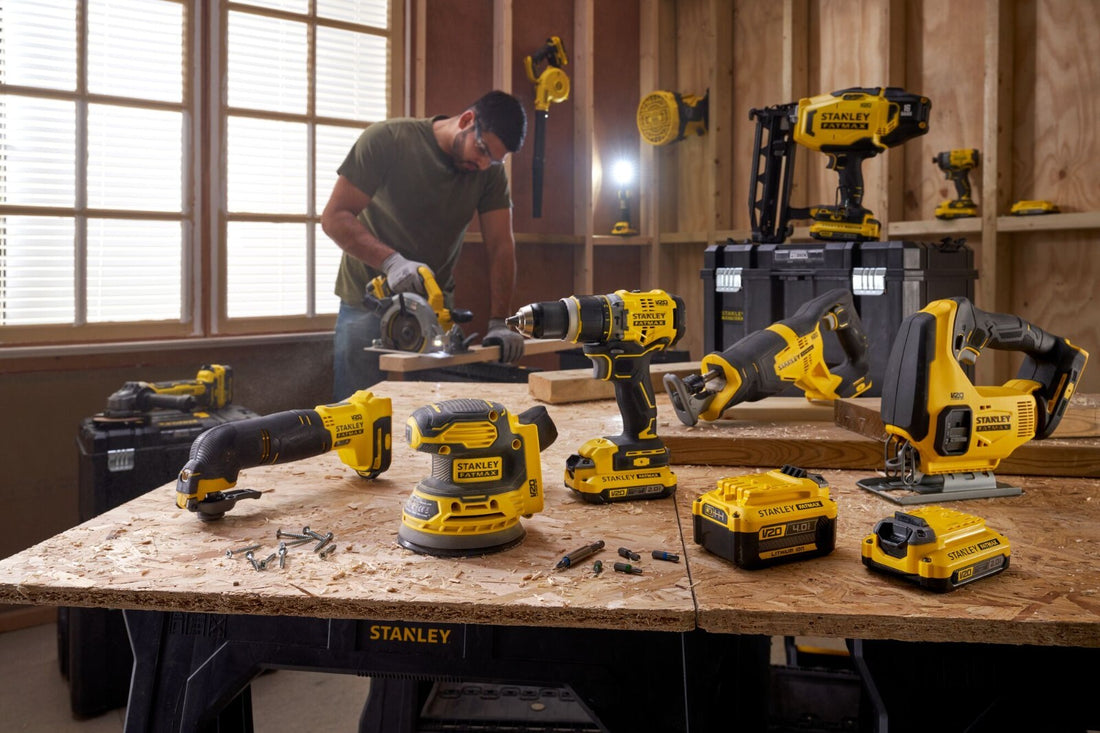 Workshop setting with a person using power tools on a workbench, surrounded by various Stanley power tools.